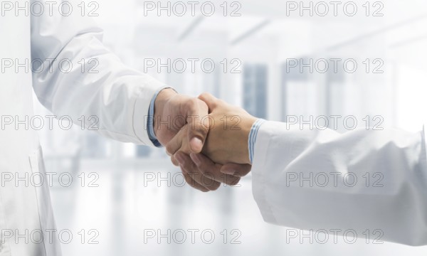 Close-up of the handshake between the two medics. Against the backdrop of the cityscape