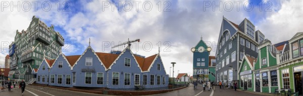 Panoramic photo 5 blue modern buildings in the traditional style of historic houses in a row and finally a modern green hotel building as with many stacked small traditional buildings of Inntel Hotels Amsterdam Zaandam in a modern part of the city centre, Zaandam, North Holland, Netherlands