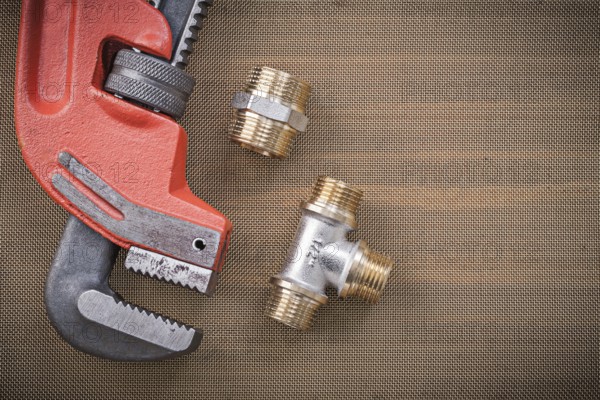Pipe wrench brass plumbing fixtures on cleaning mesh filter grid