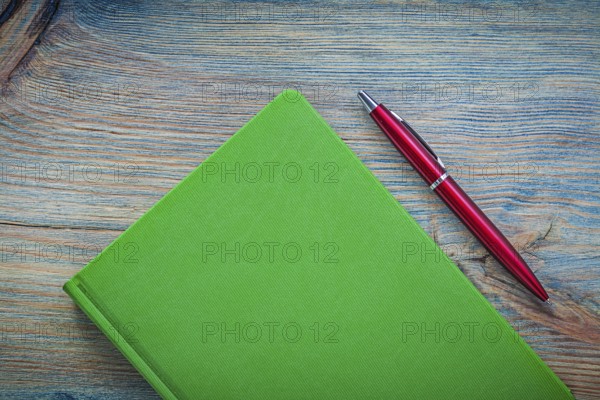 Notepad ball-point pen on wooden board top view education concept