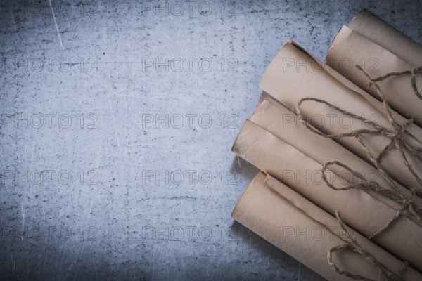 Pile of vintage paper scrolls on scratched metallic background
