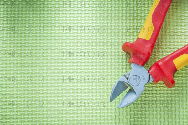 Sharp insulation nippers on green background electricity concept