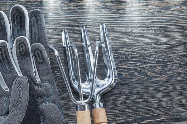 Gardening rake trowel fork protective gloves on wooden board