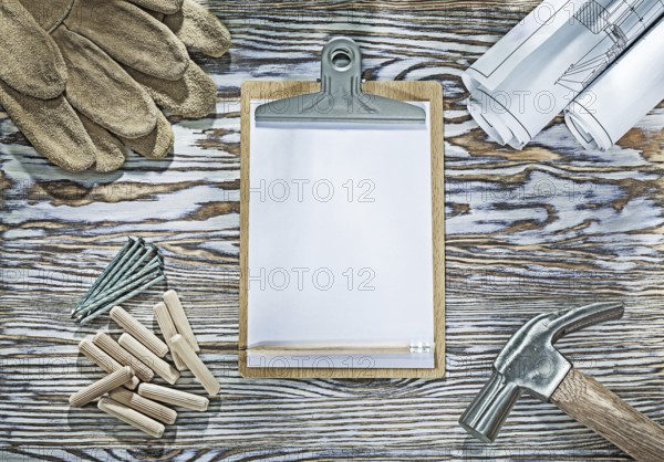 Protective gloves clipboard claw hammer blueprints nails wooden dowels