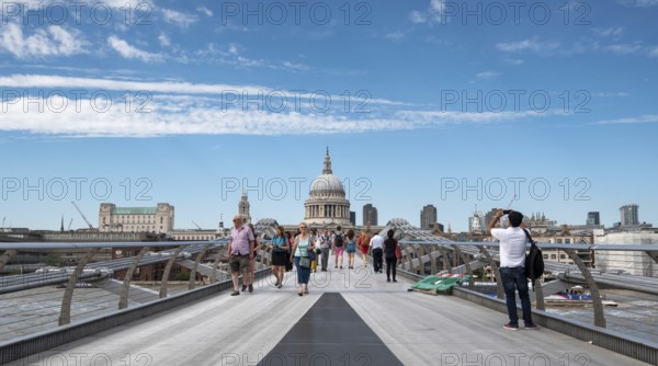 London, UK, July 5, 2019: People walking on the millennium bridge and Saint Paul Cathedral in London UK
