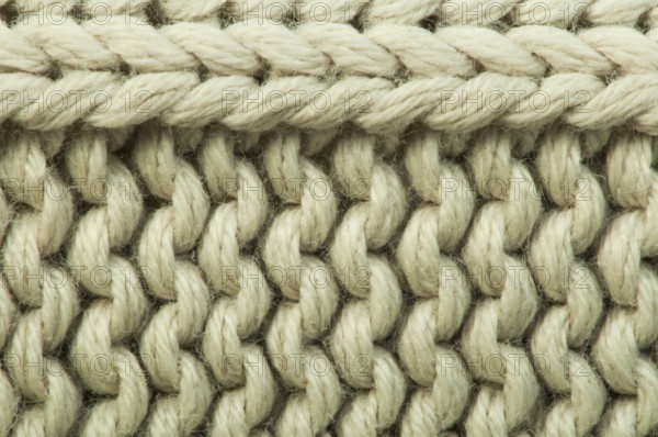 Old knit sweater background. Beige color. Studio shot