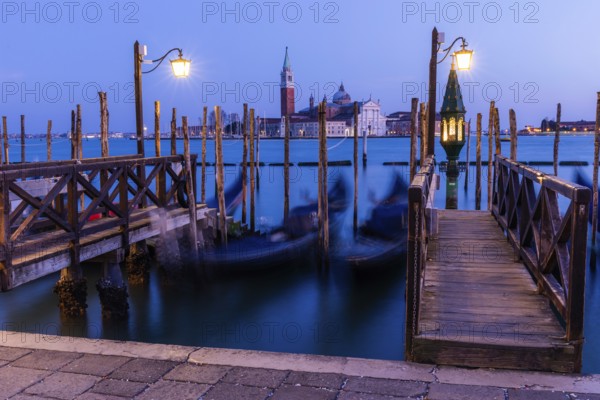 Venetian gondolas, boat dock at St Mark's Square, church of San Giorgio Maggiore in the background, blue hour, long exposure, Venice, Veneto, Italy, Europe