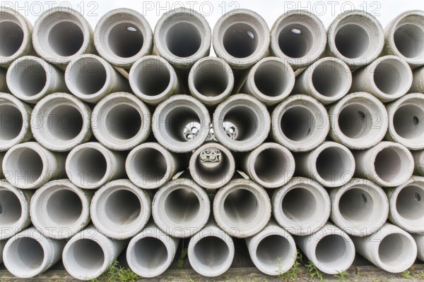 Pile of concrete sewer pipes on concrete plant grounds