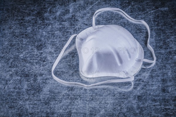 Safety dust mask on metallic background construction concept