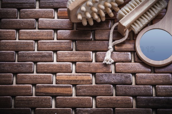 Wood massager looking-glass and peeling brush on textured wooden mat sauna concept