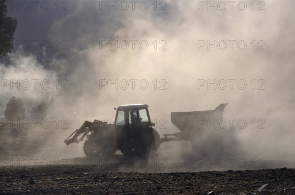 Tractor spreading lime with a fertiliser spreader, West Coast, New Zealand, Oceania
