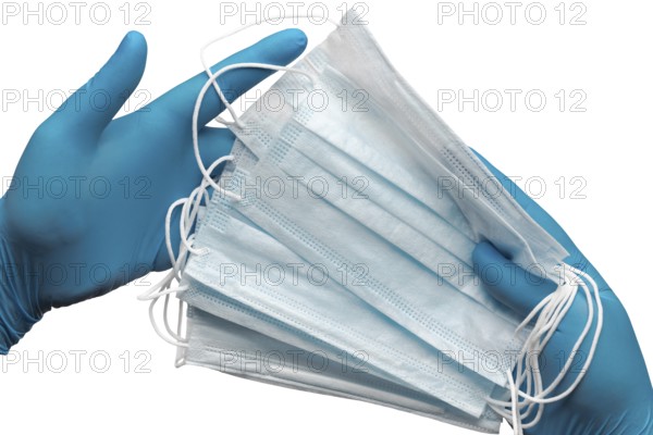Doctor holding lot medical face mask in two hands blue gloves isolated on white background. Concept coronavirus quarantine, grippe, pandemic outbreak, hygiene. Medical antibacterial bandage for face