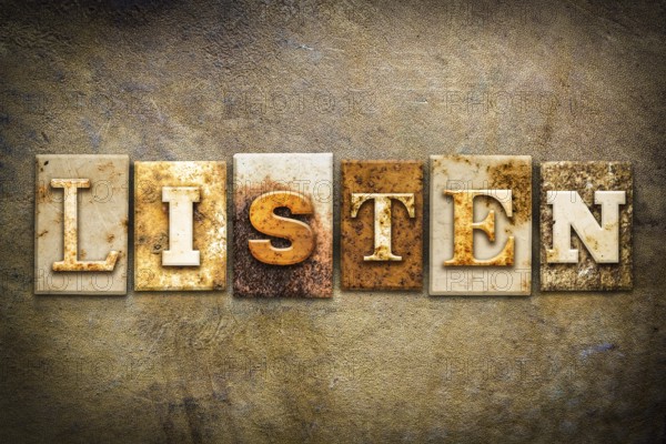 The word LISTEN written in rusty metal letterpress type on an old aged leather background