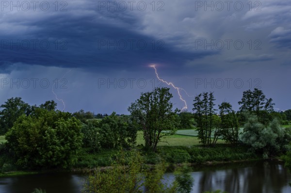 Bright flashes of lightning have illuminated the dark sky over a river, Bogen, Lower Bavaria