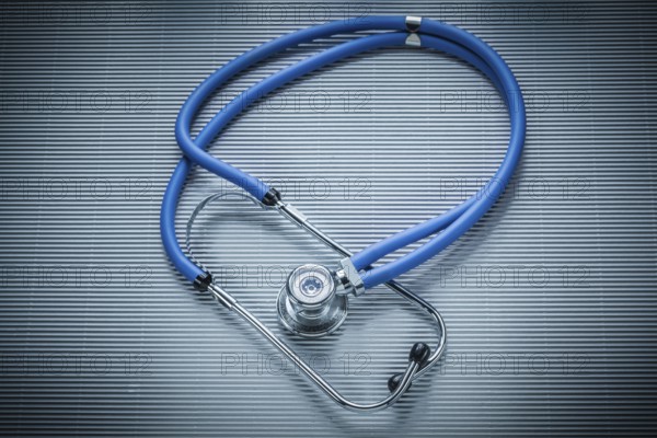Medical stethoscope on striped background, view from above