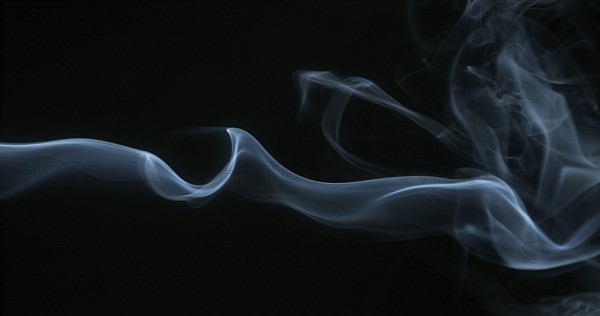 Smoke of Cigarette rising against Black Background