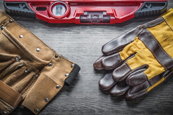 Construction level protective gloves leather tool belt on wood board
