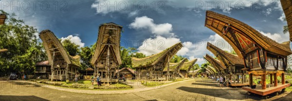 Panoramic photo of tongkonans with saddleback roofs and small square in Kete Kesu, Toraja region in Sulawesi, Indonesia, Asia