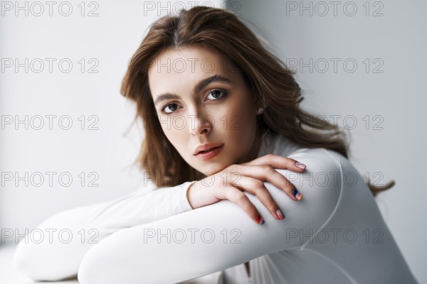 Close up portrait of sensual pretty young woman. Beautiful female model in white cloth with clean skin and sable style eyebrows posing in studio