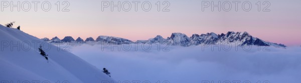panorama winter mountain landscape at sunset with snow slope and cloud cover in the foreground in the Alps of Switzerland near Bad Ragaz