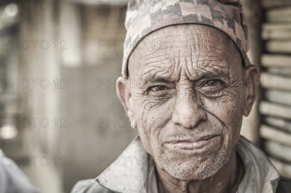 Damak, Nepal, circa April 2012: Older man with wrinkled face wears cap on his head at Nepali refugees camp in Damak, Nepal. Documentary editorial, Asia