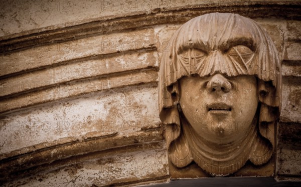 Gothic detail. Young woman portrait at the entrance of a 200 years old building in Ciutadella town, Menorca Spain