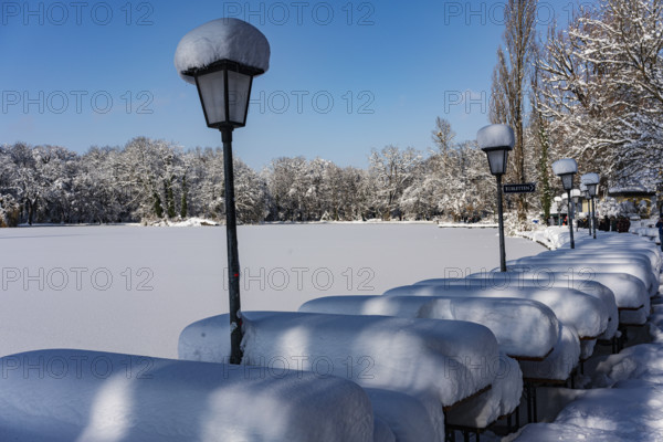 Snow on tables and lanterns, beer garden of the Seehaus, Kleinhesseloher See, winter with snow in the southern part of the English Garden, Munich, Bavaria, Germany, Europe