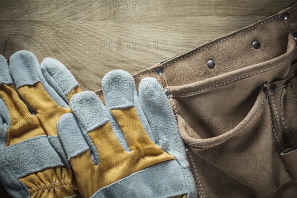 Leather tool belt Safety gloves on wooden board