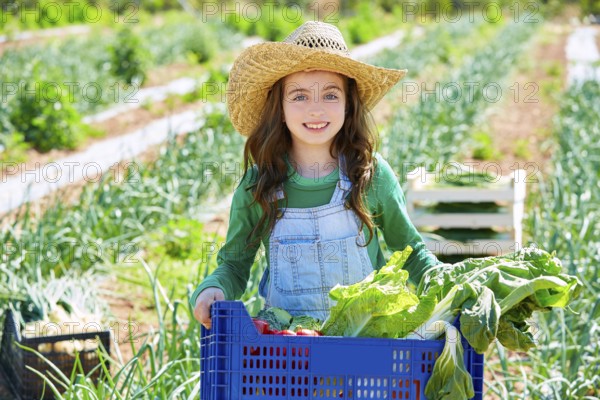 Litte kid farmer girl in vegetables harvest at orchard