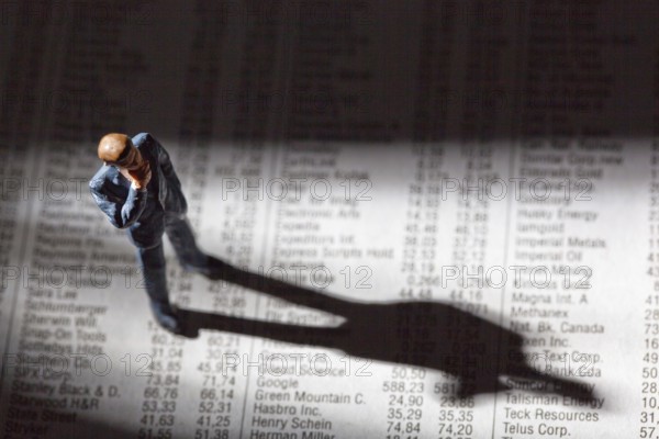 A small figure and the prices of shares in a newspaper. Earning money on the stock market. Profits and losses in share trading. Austria