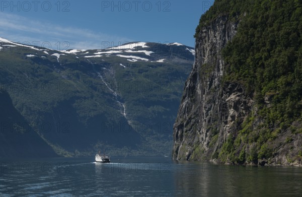 People on cruise boat at the famous geiranger fjord waterfalls in norway