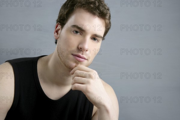 Young man portrait posing looking camera over gray background