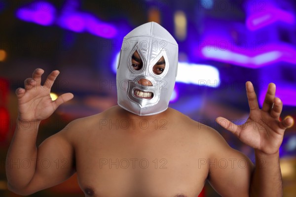 Mexican wrestling mask silver fighter with aggresive gesture night blurred lights
