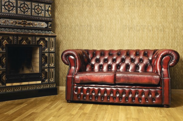 Old Red Genuine Leather Sofa Near The Fireplace