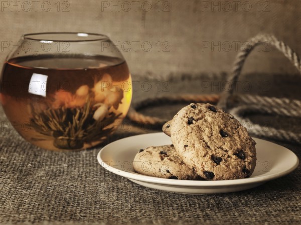 Cookies in front of blossom tea over the burlap background