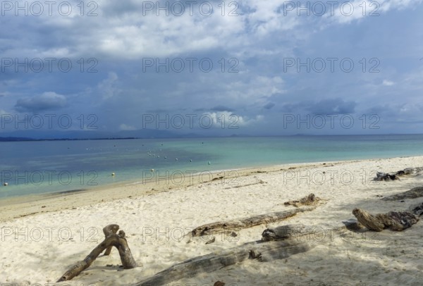 A fine, beige sandy beach on Borneo Malaysia . Intense clouds over a turquoise-coloured sea