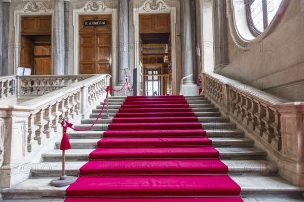 Turin, Italy, Circa January 2022: red carpet in Royal Palace, luxury elegant marble stairway, Europe