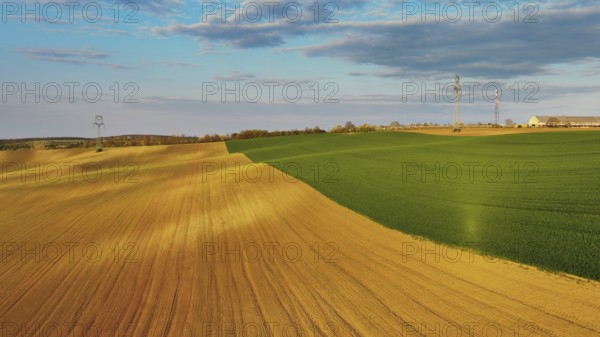 Aerial view of amazing green wavy hills with agricultural fields in evening spring. South Moravia region, Czech Republic, Europe
