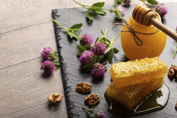 Honeycomb on slate tray with honey and nuts on kitchen table