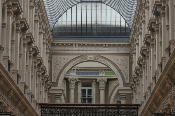 Dark historic interior with glass roof and ornate arches and columns, den haag, the netherlands