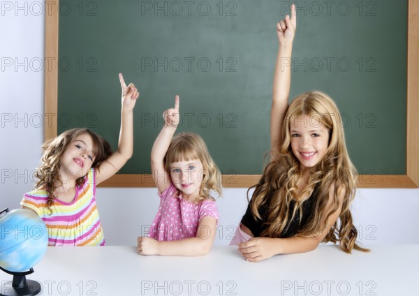 Kids student clever girls group in classroom raising hand finger