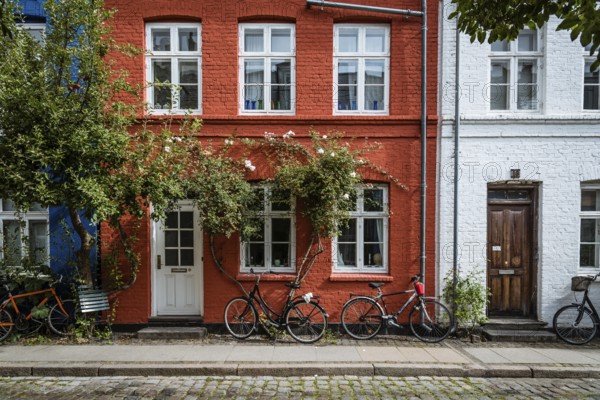 Copenhagen, Denmark, August 12, 2016. Picturesque old brick colorful houses in historical city centre of Copenhagen a cloudy day of summer, with bicycles parked, Europe