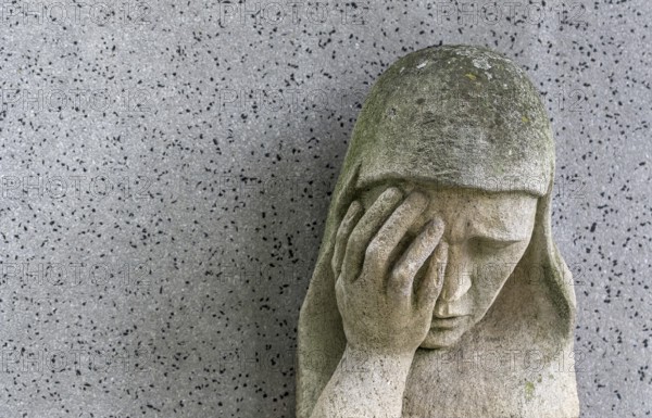 A sad Madonna in the Barbarafriedhof cemetery in Linz, Austria, Europe