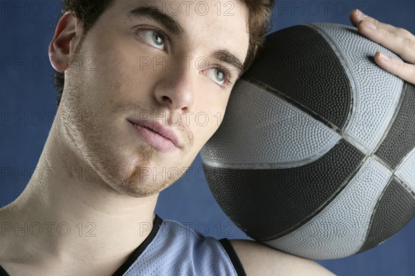 Basketball young man basket player portrait over blue studio background