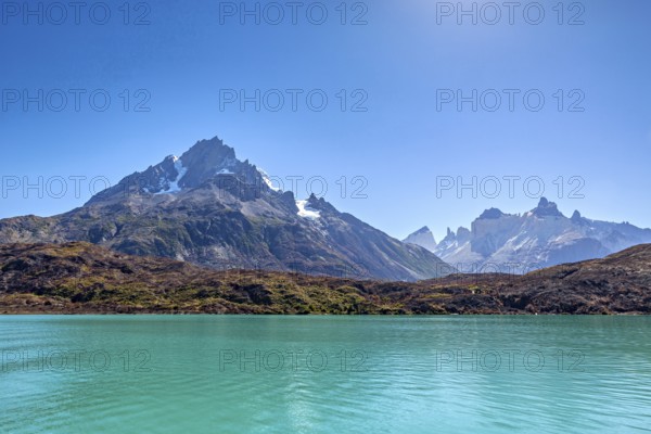 Majestic mountains with rugged peaks in front of a clear turquoise-coloured lake, the landscape of the Torres del Paine National Park in Patagonia in Chile