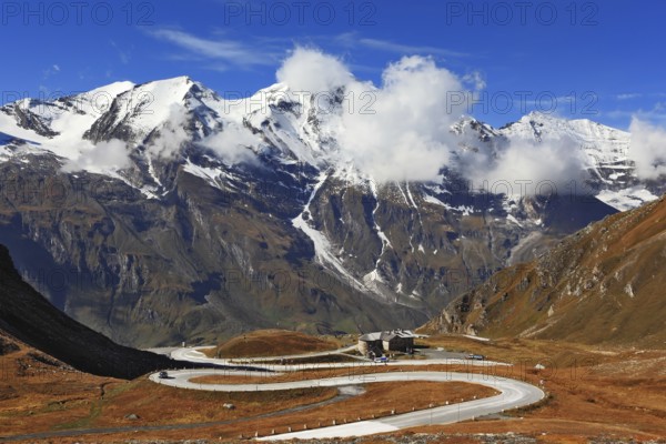 Famous picturesque views of the road in Austrian Alps - Grossglocknershtrasse. Ideal highway winds high in the mountains. The highest mountain peaks covered with fresh snow