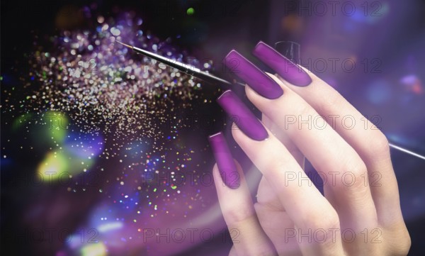 Hand with a beautiful manicure and a brush on a purple bokeh background. Nail design. Extended nails