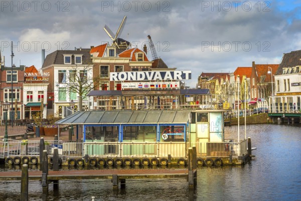 Leiden, Netherlands, April 7, 2016: Panorama with traditional dutch houses, harbour at canal and windmill in Holland