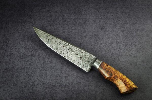 Beautiful luxurious utility knife in Texas Wind damask pattern with noble wood handle on dark background