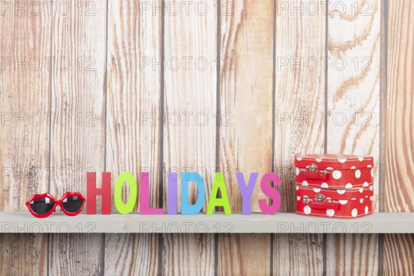 Wooden background for holidays with suitcases and sunglasses